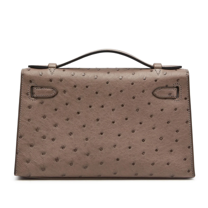 Soft Muted Taupe Grey Dotted Grain Compact Trapezoid Mini Clutch With Warm Golden Turnlock Hardware And Side Carry Attachment Ring