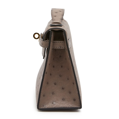 Soft Muted Taupe Grey Dotted Grain Compact Trapezoid Mini Clutch With Warm Golden Turnlock Hardware And Side Carry Attachment Ring